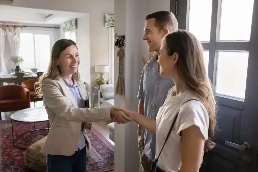 Real estate agent greeting clients at property in Albertson, NY.